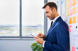© baranq - Picture of businessman using digital tablet while standing at modern office
