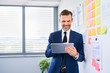 © baranq - Happy manager, businessman using digital tablet at modern office