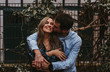 © Ekaitz Gerique/ADDICTIVE STOCK - Content young man and woman hugging and kissing while standing near metal fence on city street and enjoying summer day together