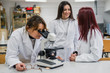 © Javier De La Torre/ADDICTIVE STOCK - Woman using microscope near colleagues in laboratory