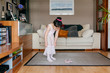 © Manuel Ruiz Alba/ADDICTIVE STOCK - Cute little girl in light pink leotard and tights putting on skirt while standing near dance shoes in cozy living room at home