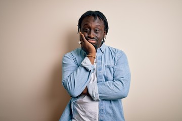 Poster - Young handsome african american man wearing casual denim shirt over white background thinking looking tired and bored with depression problems with crossed arms.