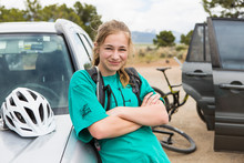 Portrait Of Teen Girl Leaning On SUV After Mountain Biking