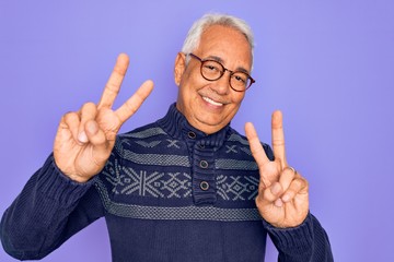 Canvas Print - Middle age senior grey-haired man wearing glasses and winter sweater over purple background smiling looking to the camera showing fingers doing victory sign. Number two.