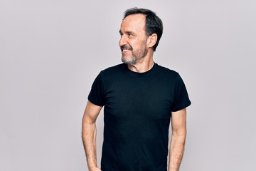 Sticker - Middle age man wearing casual black t-shirt standing over isolated white background looking to side, relax profile pose with natural face and confident smile.