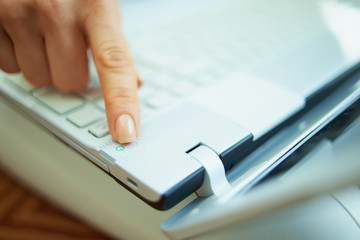 woman in house in sunny day turningshutdown laptop