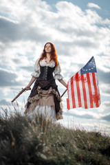 Wall Mural - Girl in historical dress of 18th century with flag of United States. July 4 is US Independence Day. Woman of patriot freedom fighter in outdoor on background cloudy sky