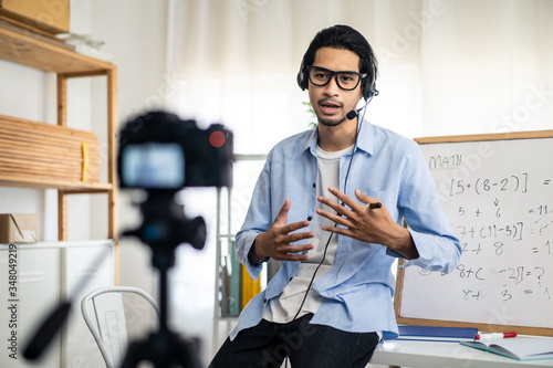 Fotografía Asian school male teacher working from home teaching online math subject to student studying from home