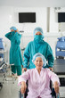 © DragonImages - Senior Asian woman sitting in wheelchair in operating theater in ophthalmology clinic. She is ready for surgery