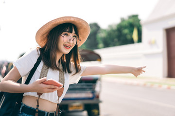 Wall Mural - Young asian traveller woman call a taxi for tourism in Bangkok.