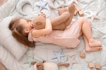 little girl with toys lying on floor