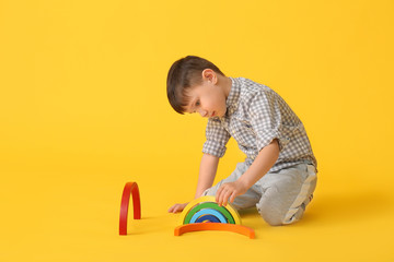 Poster - Little boy with toy on color background