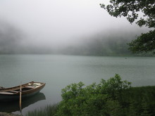 Rowboat Moored On Lake In Foggy Weather