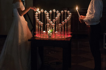 bride and groom light candles at a wedding