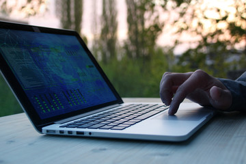 man, businessman, programmer, working in the evening at a laptop on the balcony of his house, hands 