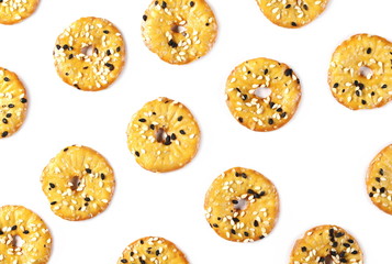 Baked pretzels with black and white sesame seeds, savory snacks isolated on white background, top view