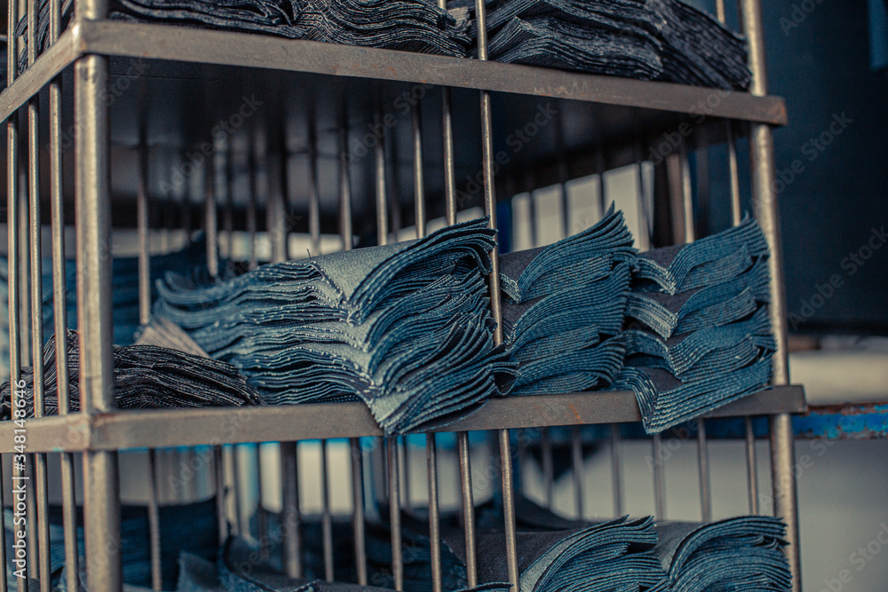 Przemysł odzieżowy, produkcja spodni jeansowych, farbowanie, szycie, pranie, krojenie. - obrazy, fototapety, plakaty 