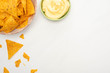 top view of corn nachos with cheese sauce on white background