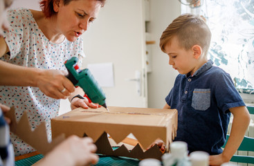 Wall Mural - Mom and kids making a cardboard dinosaur costume	
