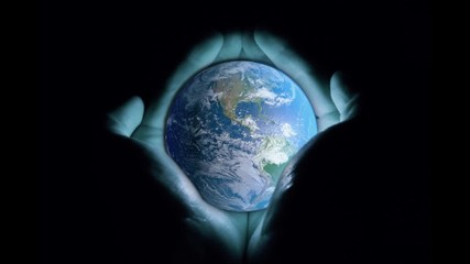 3d animation: men's hands holding the rotating planet earth with a blue glow on a black background. 