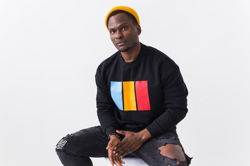 Wall Mural - Handsome African American man posing in black sweatshirt on a white background. Youth street fashion photo with afro hairstyle.