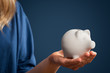 Saving money concept with woman holding white  piggy bank
