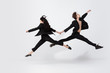 © master1305 - Young and graceful ballet dancers in minimal black style isolated on white studio background. Art, motion, action, flexibility, inspiration concept. Flexible caucasian ballet dancers, weightless jumps