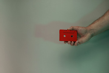 Poster - Hand holding red audio cassette tape in the color light. Beautiful minimal in neon light. Minimalism retro style concept. Background pattern for design.