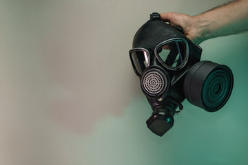 Poster - Hand hold black old gas mask in the color light. Beautiful old minimal in neon light. Minimalism retro style concept. Background pattern for design.