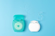 Dental floss containers on blue background. Daily oral hygiene, teeth care and health. Cleaning products for your mouth, copy space. Dental care concept.