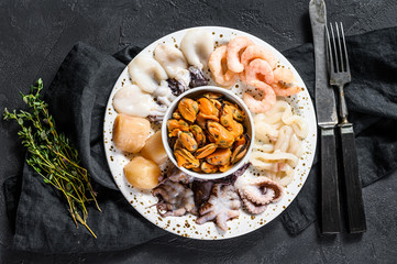 Boiled seafood mix, sea cocktail. Black background. Top view. Space for text