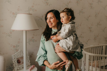 pretty young mother with her little daughter in the room