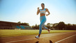 © Gorodenkoff - Beautiful Fitness Woman in Light Blue Athletic Top and Leggings Jogging in a Stadium. She is Running on a Warm Summer Afternoon. Athlete Doing Her Routine Sports Practice on a Track.