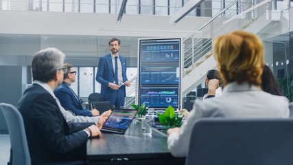 Wall Mural - In the Corporate Meeting Room: Ambitious Executive Uses Digital Interactive Whiteboard for Presentation to a Board of Directors, Lawyers, Investors. Screen Shows Company Growth Data with Digital Graph