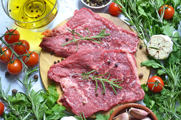 fresh vegetables and raw meat with herbs and spices, food background top view