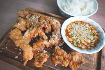 traditional Thai culture fried pork cuisine style or moo tod one of the most favorite famous street fast foods menu at thailand homemade
with hot spicy sauces on table wood dish sticky rice vegetable