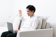 © Gengwit - Attractive asian male working with computer laptop at home.  Video conferencing call via computer