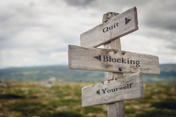 Wall Mural - quit blocking yourself text engraved on old wooden signpost outdoors in nature. Quotes, words and illustration concept.