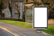Empty bus stop in town with blank mock up vertical billboard for advertising.