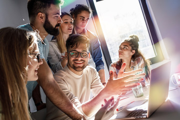 Group of programmers and designers in a conference room. They're discussing development of a new project.	