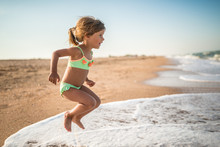 Joyful Little Girl Enjoys A Beach Day While Relaxing At Sea On A Sunny Warm Summer Day. Summer Vacation And Relaxation Concept