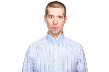 Wall Mural - portrait of a joyful surprised man in a classic blue shirt; with eyes wide open with delight and admiration; look into the camera. Isolated