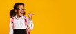 © Prostock-studio - Excited School Girl Pointing Thumb At Empty Space, Yellow Background