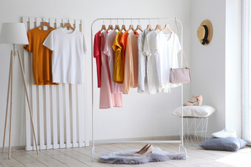 Wall Mural - fashionable clothes on a rack in the interior of a bright room
