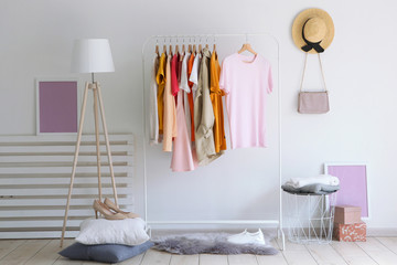 Wall Mural - fashionable clothes on a rack in the interior of a bright room
