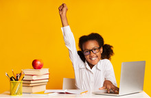 Happy African Schoolgirl At Laptop Raising Hand, Yellow Background, Studio