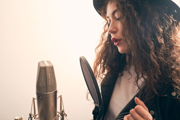 Wall Mural - Pretty female singer recording in music studio