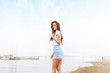 © Mirrorstudio - Young beautiful happy woman walks on beach in marina