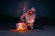 Arab young man sitting around bonfire in the desert, Arabic comping, middle east tourism concept.