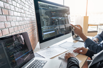Two professional programmer cooperating and working on web site project in a software developing on desktop computer at company, codes and typing data code, Programming with HTML, PHP and javascript